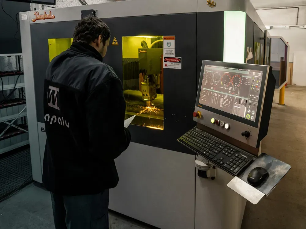 Doświadczony operator kontrolujący proces cięcia laserem fiber na panelu CNC